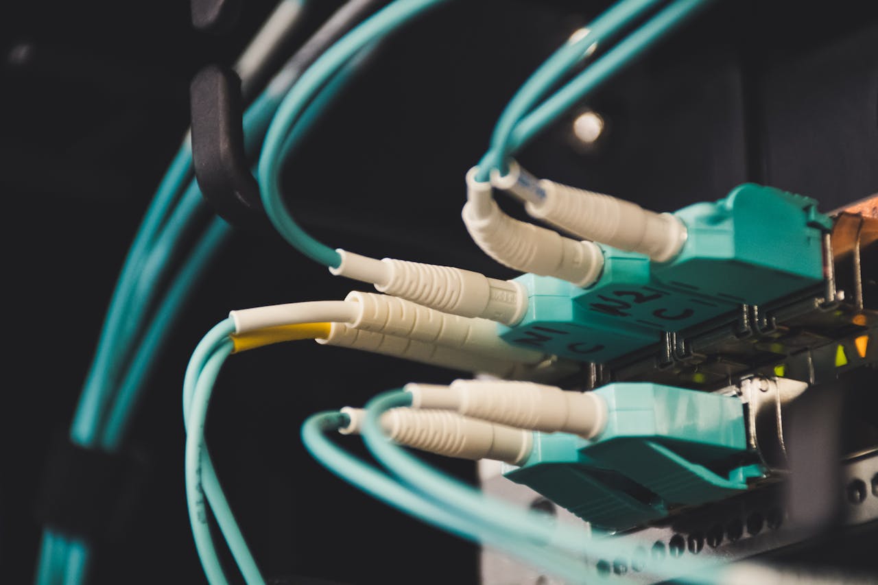 about-02 Detailed view of fiber optic cables and ports in a server room, showcasing connectivity.